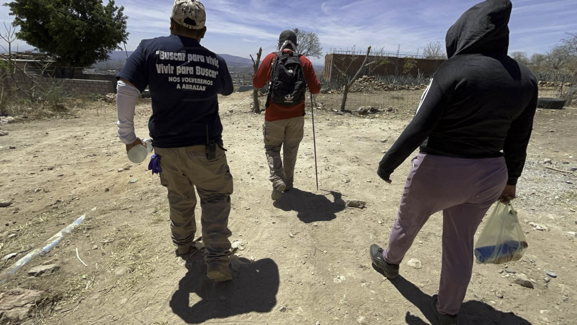 Al salir de casa, frente al altar con imágenes religiosas que incluyen la fotografía de su hermano, Alex se despide de él. Luego se persigna y se cubre el rostro antes de salir a buscarlo.
